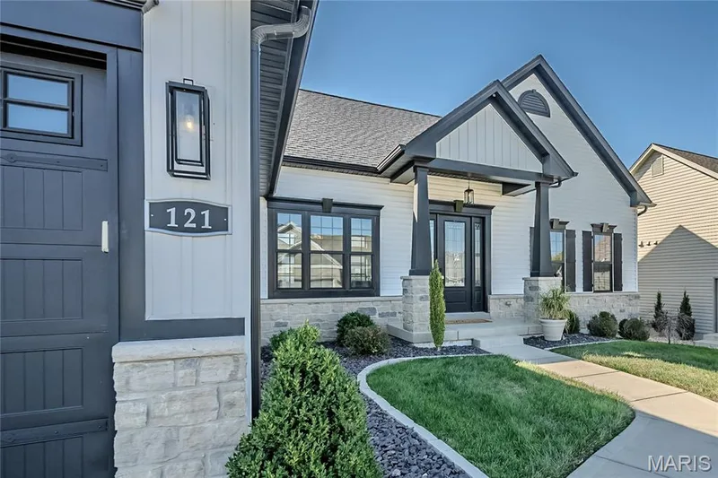 121 just could be your lucky numbers.  This photo gives you the opportunity to see the elevation detail of this property. Notice the stone skirting and the pedestal treatment of the craftsman porch detail. The mix of Board and Batten Siding and vertical New England profile siding to emphasize the soaring gables and window detail. — 121 Eagle Estates Drive, Lake St. Louis, MO 63367