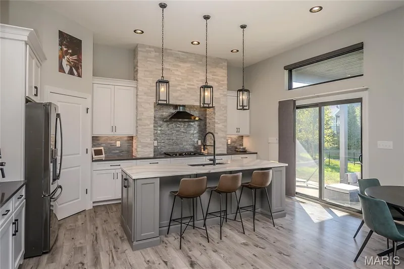 There are so many stars and supporting actors to this Kitchen scape.The natural stone against the shimmering tile.  Sleek counter against the platinum island and controlled lighting to match the mood of the moment. — 121 Eagle Estates Drive, Lake St. Louis, MO 63367