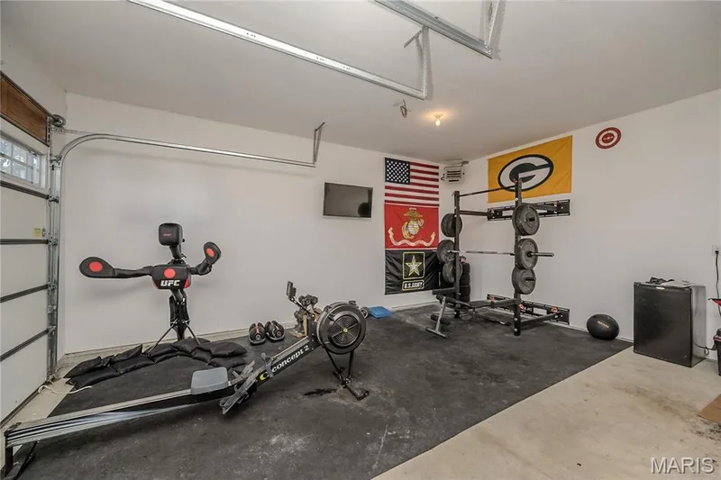 The third bay of the garage is currently used as a gym for the owner.  When he not painting, he is pumping iron.  He is a bit pampered with the two heaters that warm up the garage.  For the resident mechanic, you will never be out in the cold.  TV is handy for binge watching, while you are working on your arms are detailing your car. — 121 Eagle Estates Drive, Lake St. Louis, MO 63367