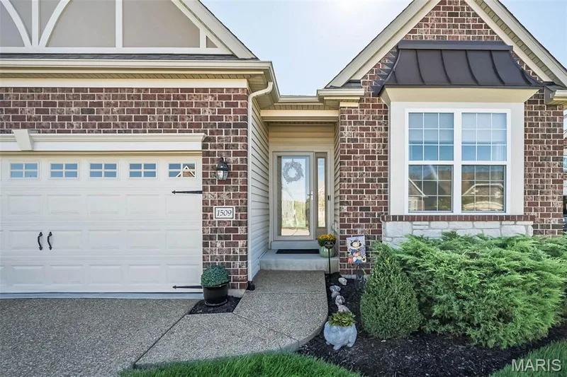 Brick and stone facade with a garage, bay window, and covered entry — 1509 Woodside Hills Drive, St Peters, MO 63376