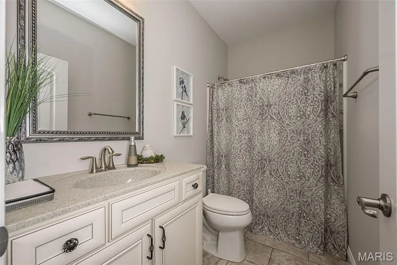White vanity with an integrated sink, brushed nickel faucet, and framed mirror — 1509 Woodside Hills Drive, St Peters, MO 63376