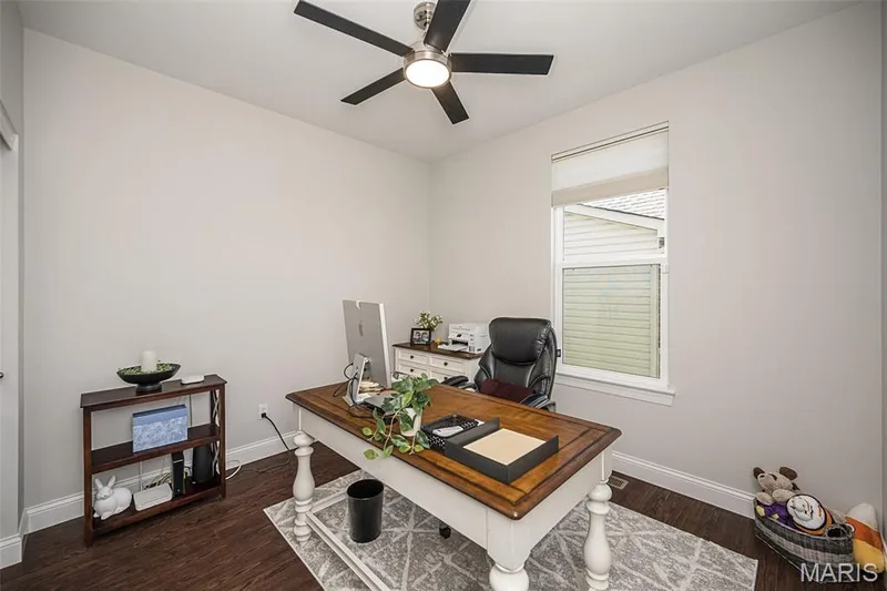 Wood-finish flooring, single window with roller shade, ceiling fan with integrated lighting, and neutral wall tones — 1509 Woodside Hills Drive, St Peters, MO 63376