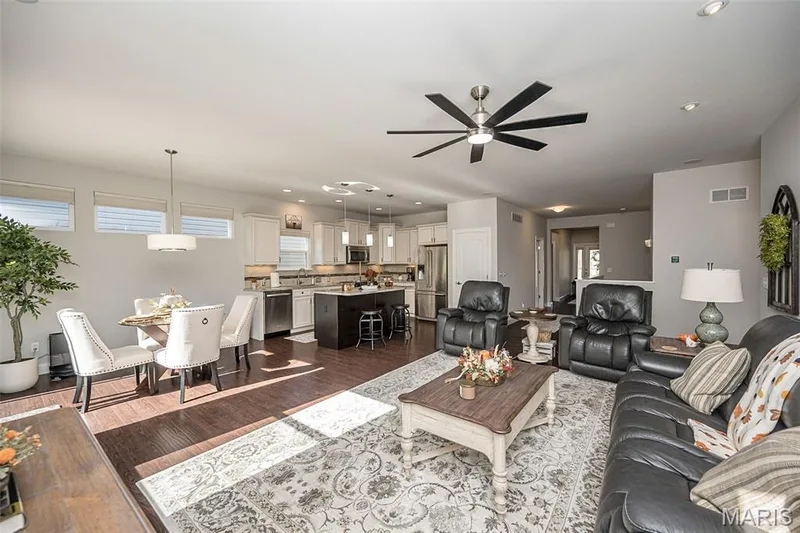 Open-concept living area with dark wood-finish flooring, recessed lighting, and a contemporary ceiling fan — 1509 Woodside Hills Drive, St Peters, MO 63376
