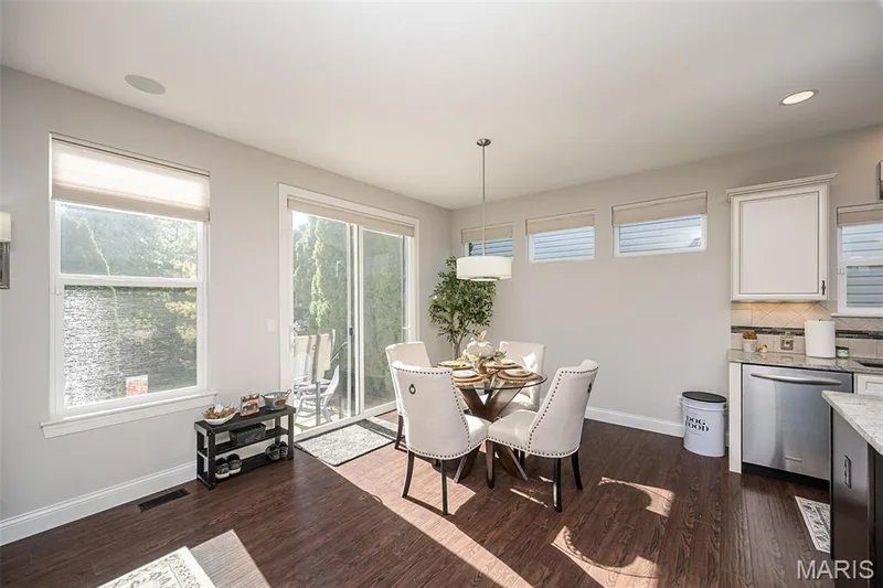 Wood-finish flooring throughout, multiple windows with blinds, recessed lighting, and a glass sliding door providing access to an exterior patio — 1509 Woodside Hills Drive, St Peters, MO 63376