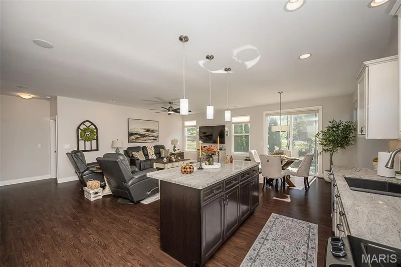 Open-concept living space featuring wood-finish flooring, recessed lighting, and a kitchen island with pendant lighting — 1509 Woodside Hills Drive, St Peters, MO 63376
