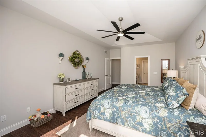 Tray ceiling with modern ceiling fan, wood-finish flooring, and light wall paint throughout — 1509 Woodside Hills Drive, St Peters, MO 63376