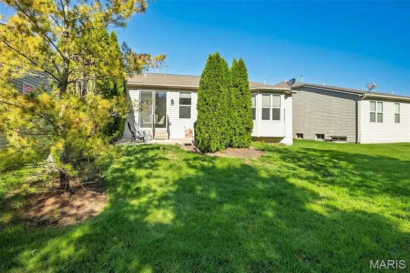 Expansive grassy yard with mature trees and a private patio — 1509 Woodside Hills Drive, St Peters, MO 63376