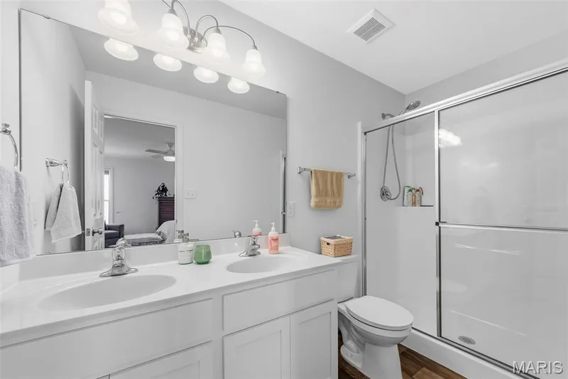 A spacious private bath featuring double sinks, a separate shower, and plenty of room to get ready for the day! — 6002 Suntan Drive, St Charles, MO 63301