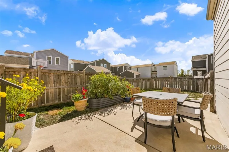 Enjoy outdoor living in this fenced backyard featuring a spacious patio for entertaining and raised garden beds ready for your green thumb! — 6002 Suntan Drive, St Charles, MO 63301