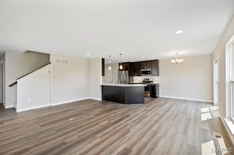 Kitchen with hardwood / wood-style floors, hanging light fixtures, appliances with stainless steel finishes, dark brown cabinets, and a chandelier — 2 Burlington at Fairmount Grove, St Peters, MO 63376