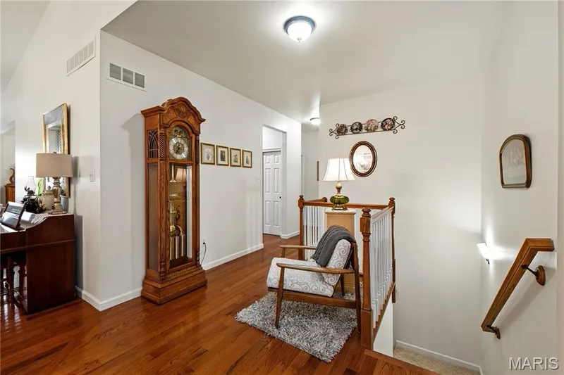 Hardwood-finish flooring, white painted walls, and a wood railing system — 149 Amiot Court, Chesterfield, MO 63146
