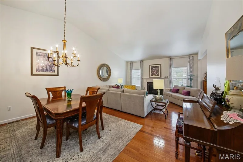 Vaulted ceiling, hardwood flooring, fireplace with white mantel, recessed windows, and a chandelier — 149 Amiot Court, Chesterfield, MO 63146