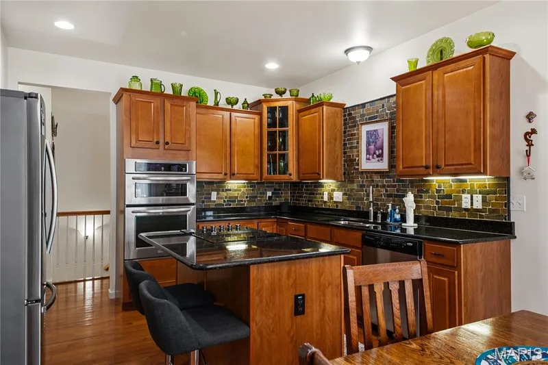 Wood-finish flooring, recessed lighting, double wall oven, stainless steel refrigerator, and a dark stone countertop — 149 Amiot Court, Chesterfield, MO 63146