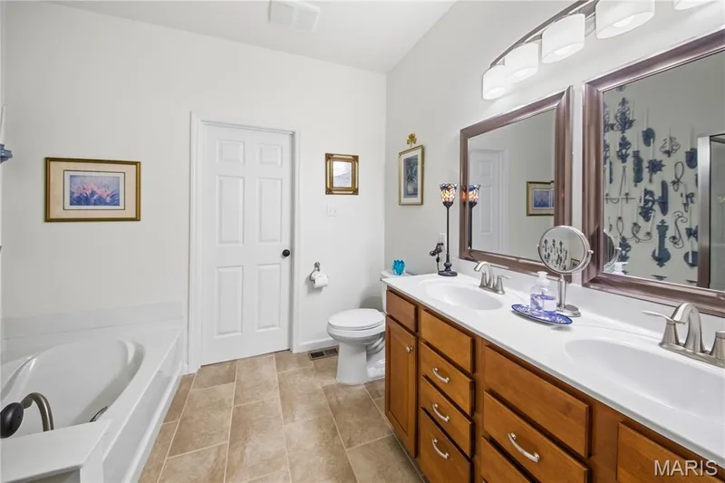 Dual vanity with integrated sinks, wood-finish cabinetry, and brushed nickel hardware — 149 Amiot Court, Chesterfield, MO 63146