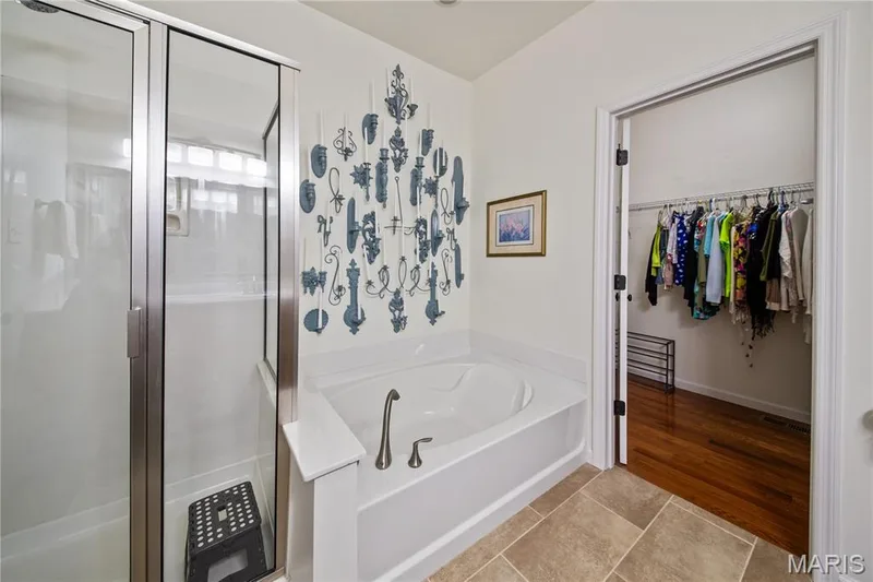 Built-in soaking tub with brushed nickel fixtures, glass-enclosed shower, and large format floor tiling — 149 Amiot Court, Chesterfield, MO 63146