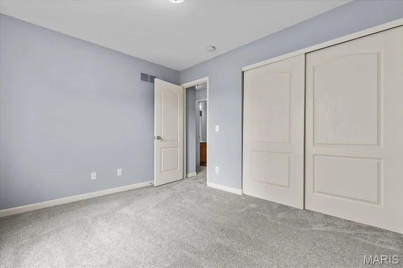 Neutral-toned carpeting, light blue wall paint, white trim, and a white interior door — 521 Cimarron Woods Court, Wentzville, MO 63385