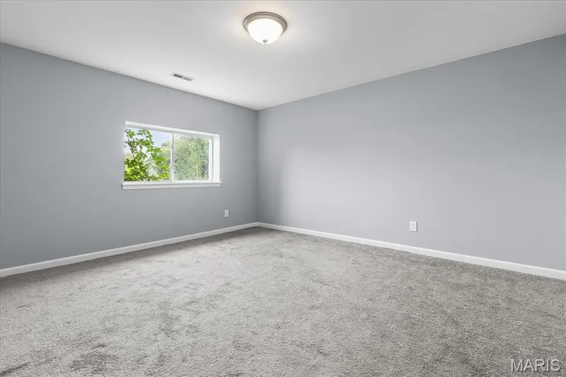 Recessed window with white trim, wall-to-wall carpeting, light-toned wall paint, and a ceiling-mounted light fixture — 521 Cimarron Woods Court, Wentzville, MO 63385