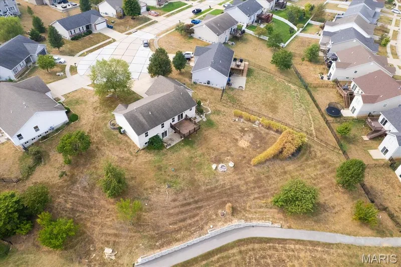 Residential property with a wood deck, mature trees, and landscaping — 521 Cimarron Woods Court, Wentzville, MO 63385
