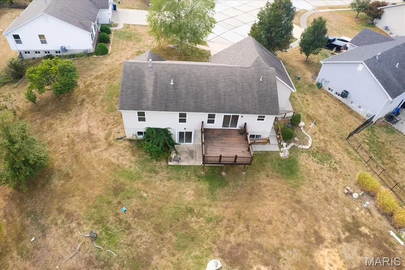Rear elevation with an elevated wood deck and concrete patio — 521 Cimarron Woods Court, Wentzville, MO 63385