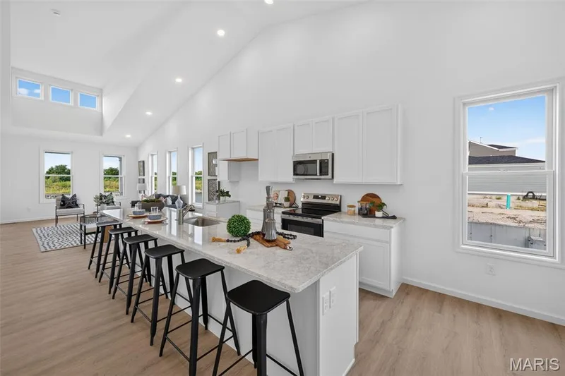 Vaulted ceilings, recessed lighting, LVP flooring, white cabinetry, and stainless steel appliances — 2974 Memphis Street, St Charles, MO 63301