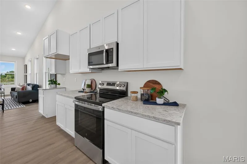 White cabinetry with a stainless steel microwave and electric range — 2974 Memphis Street, St Charles, MO 63301