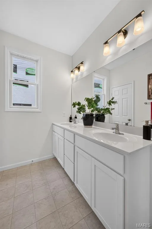 Dual vanity with undermount sinks, white cabinetry, a large wall-mounted mirror — 2974 Memphis Street, St Charles, MO 63301