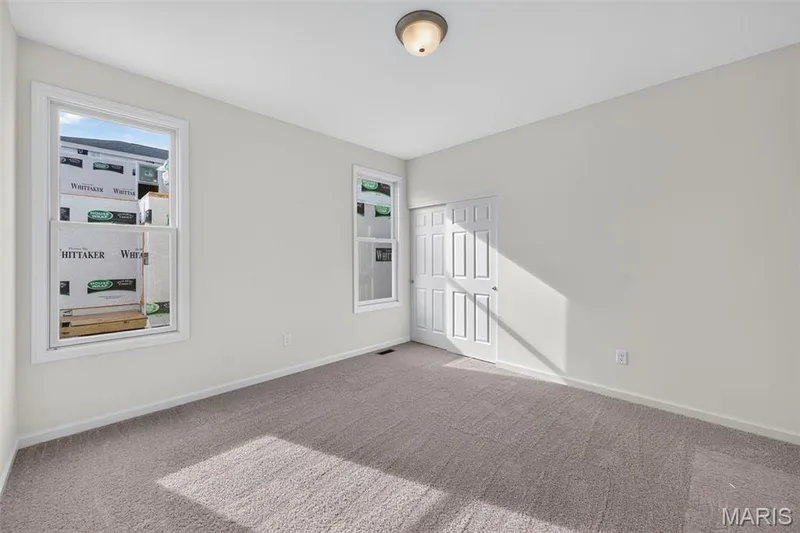 Wall-to-wall carpeting, dual windows, neutral wall tones, and a paneled closet door — 2974 Memphis Street, St Charles, MO 63301