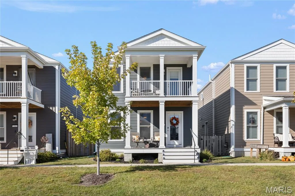 Two-story exterior with a covered porch and upper-level balcony, siding, and a gabled roofline — 200 Tiber Way, St Charles, MO 63301