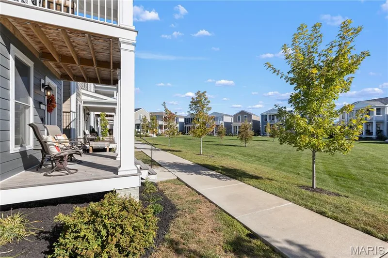 Covered 2-story double porch with white railings and dark blue/gray siding — 200 Tiber Way, St Charles, MO 63301
