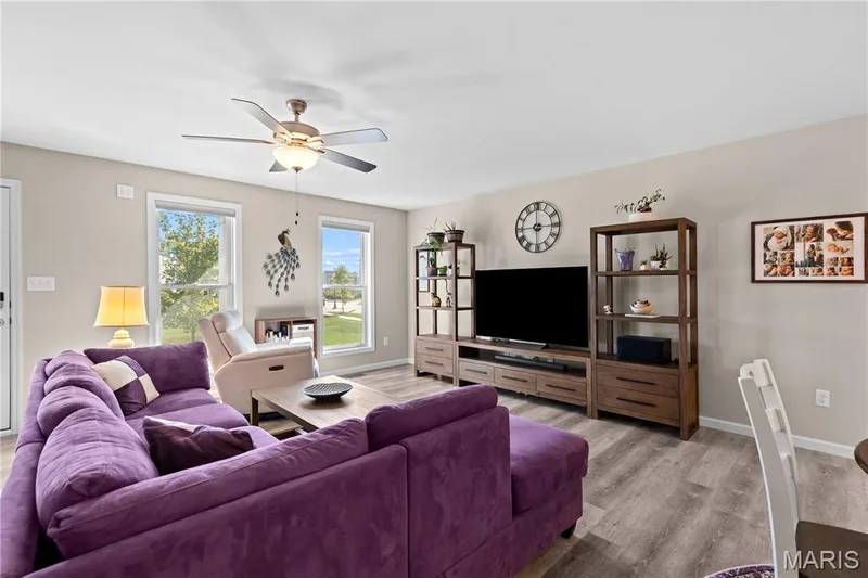 Neutral wall color, luxury vinyl plank flooring, ceiling fan with integrated lighting, and multiple windows — 200 Tiber Way, St Charles, MO 63301