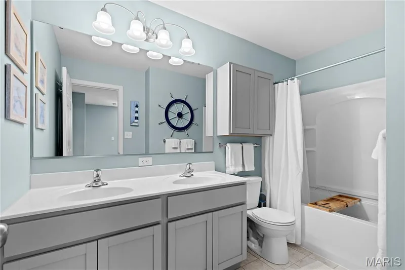 Guest bathroom with dual vanity with integrated sinks, ample countertop space, and under-sink cabinetry — 200 Tiber Way, St Charles, MO 63301