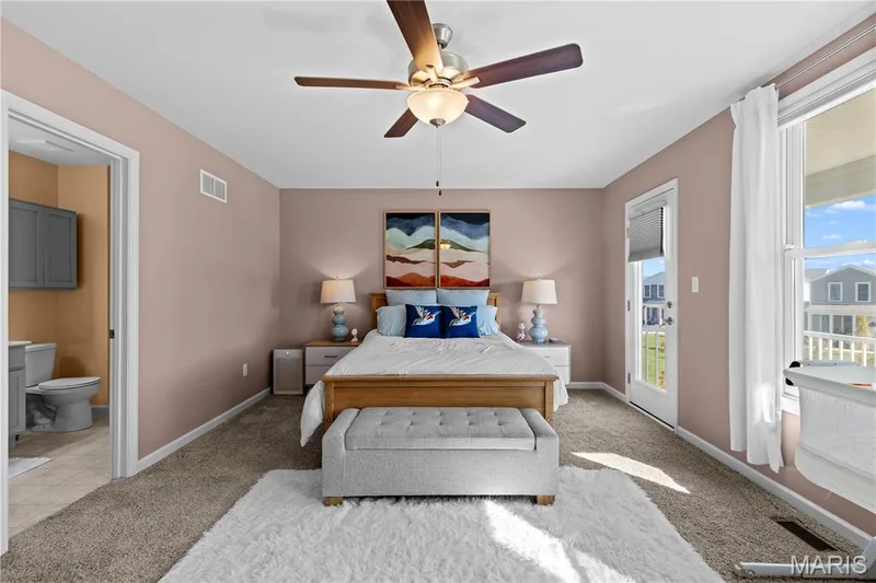Carpeted bedroom featuring a ceiling fan with integrated lighting, a full-light door leading to 2nd story balcony overlooking the community green space, and a large window — 200 Tiber Way, St Charles, MO 63301