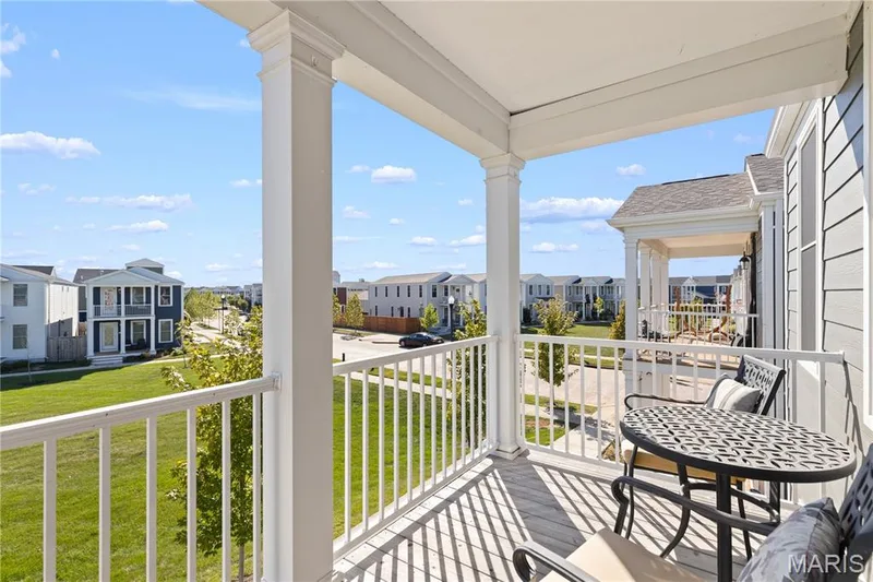Covered 2nd-story balcony with white railing, wood-finish flooring, and white support columns — 200 Tiber Way, St Charles, MO 63301