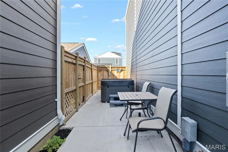 Private, New Orleans–inspired courtyard featuring a hot tub, patio and wood privacy fence — 200 Tiber Way, St Charles, MO 63301