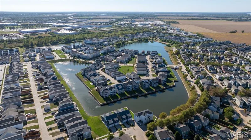 Community featuring multiple residential structures, a central body of water, and surrounding green spaces — 200 Tiber Way, St Charles, MO 63301