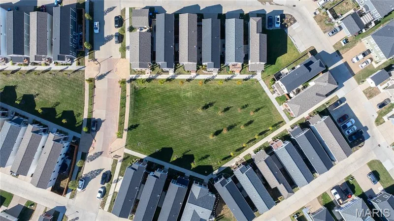 Central green space surrounded by residential properties, featuring a manicured lawn and landscaping — 200 Tiber Way, St Charles, MO 63301