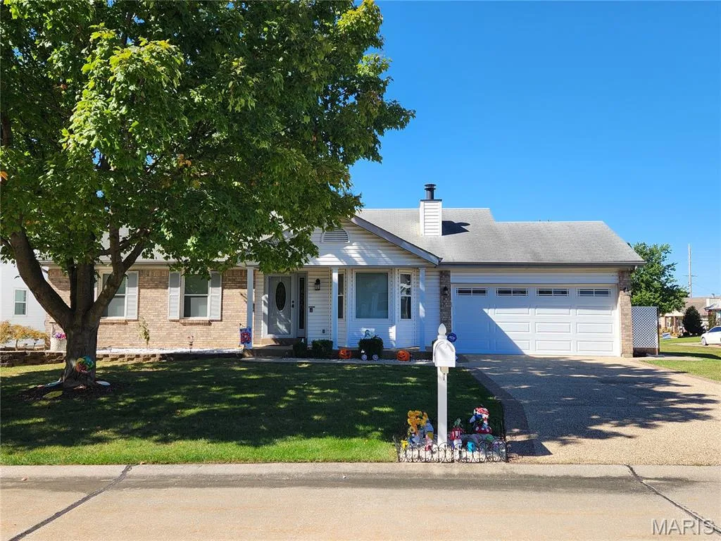Brick and siding exterior with a covered porch, attached two-car garage, and aggregate driveway — 101 Eric Craig Court, St Peters, MO 63376