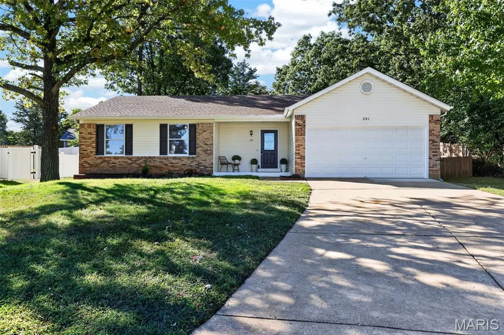 Ranch-style exterior with brick and siding, featuring a two-car garage, concrete driveway, and front entry — 341 Westbrook Drive, O'Fallon, MO 63366
