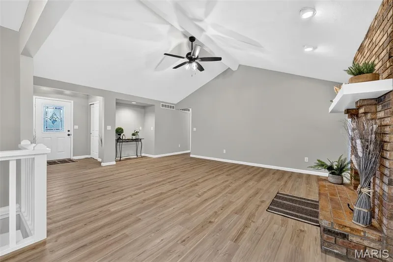 Vaulted ceiling, ceiling fan, brick fireplace, wood-finish flooring, white painted railing — 341 Westbrook Drive, O'Fallon, MO 63366