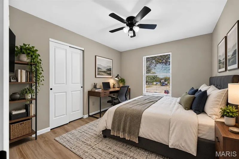Wood-finish flooring, white bi-fold closet doors, ceiling fan with integrated lighting, and a single window — 341 Westbrook Drive, O'Fallon, MO 63366