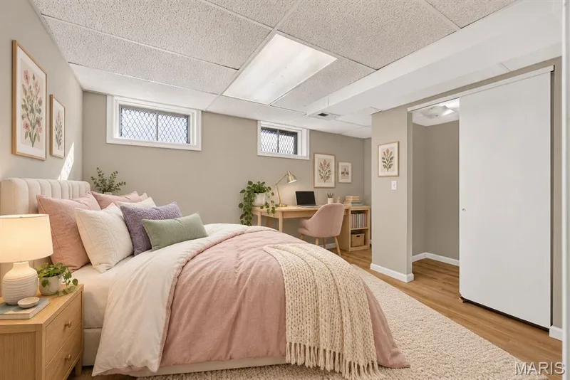 Wall-to-wall carpeting with wood-finish flooring, drop ceiling with integrated lighting, two windows with security bars, and a sliding closet door — 341 Westbrook Drive, O'Fallon, MO 63366