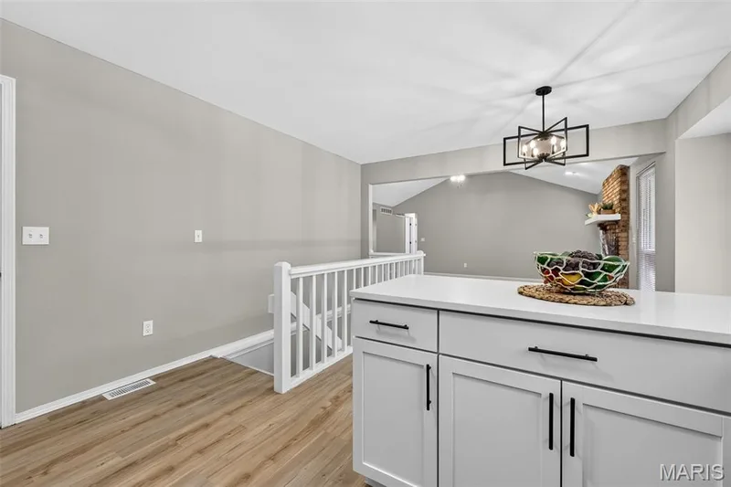 Kitchen island with white countertop and light-colored cabinetry — 341 Westbrook Drive, O'Fallon, MO 63366
