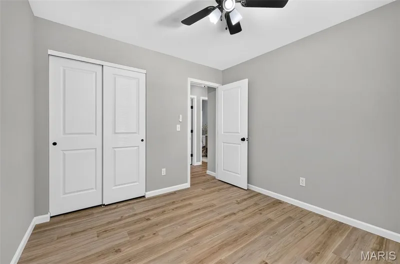 Wood-finish flooring, light gray wall paint, white trim, and a ceiling fan with integrated lighting — 341 Westbrook Drive, O'Fallon, MO 63366