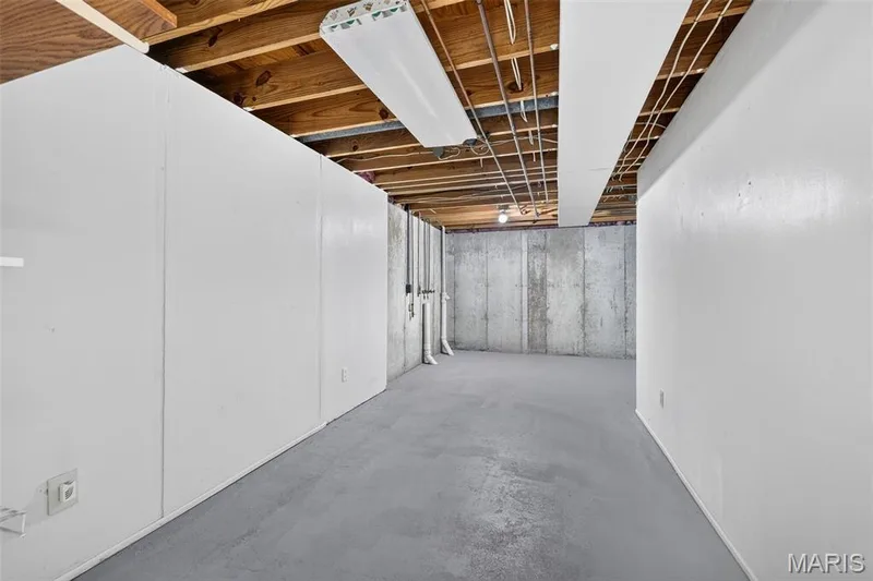 Unfinished basement with exposed ceiling joists and concrete walls — 341 Westbrook Drive, O'Fallon, MO 63366
