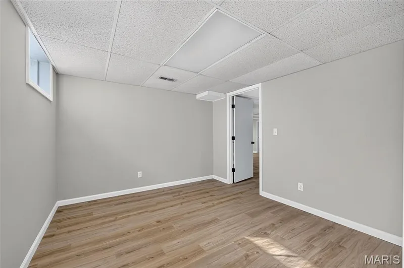 Wood-finish flooring, light gray walls, white trim, drop ceiling, and a single window — 341 Westbrook Drive, O'Fallon, MO 63366