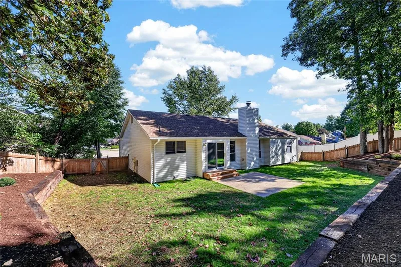 Charming single-story home with light-colored siding and dark roof accents, situated on a spacious lot surrounded by mature trees — 341 Westbrook Drive, O'Fallon, MO 63366
