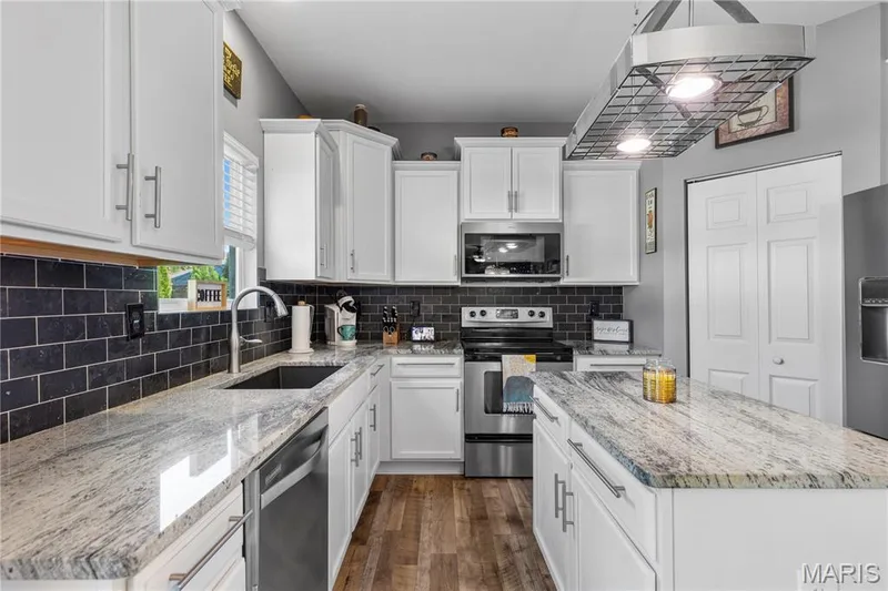 Large walk in corner pantry, granite countertops & kitchen island make gourmet meals easy for the chef of the home! — 2542 Amber Willow Court, Lake St. Louis, MO 63367
