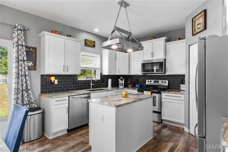 The Kitchen is a 10/10 with tasteful backsplash, custom white cabinets & stainless steel appliances! — 2542 Amber Willow Court, Lake St. Louis, MO 63367