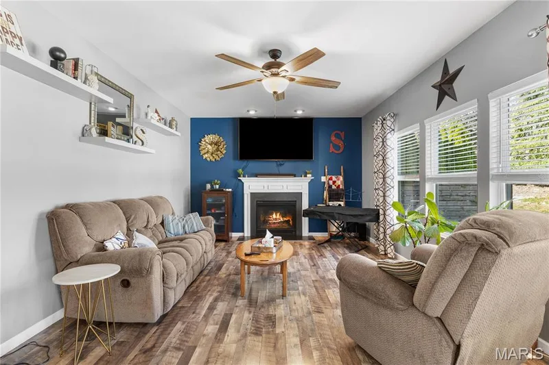 Living Room with LVP, cozy fireplace & lots of natural light from wall of windows! — 2542 Amber Willow Court, Lake St. Louis, MO 63367