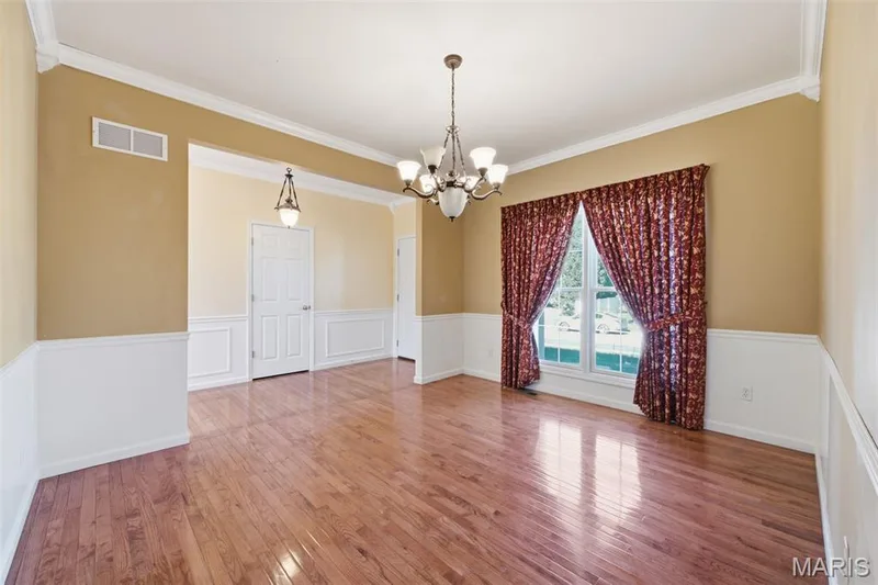 Spacious formal dining room with crown molding and chair rail. — 1615 Wainscott Court, O'Fallon, MO 63366